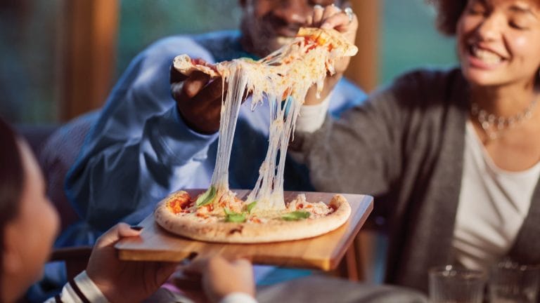A female getting a slice of pizza