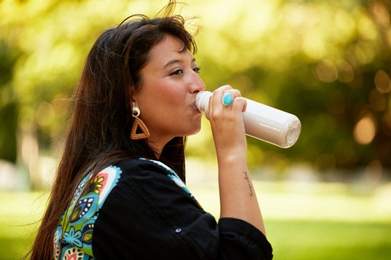 A woman drinking a cold bottle of milk