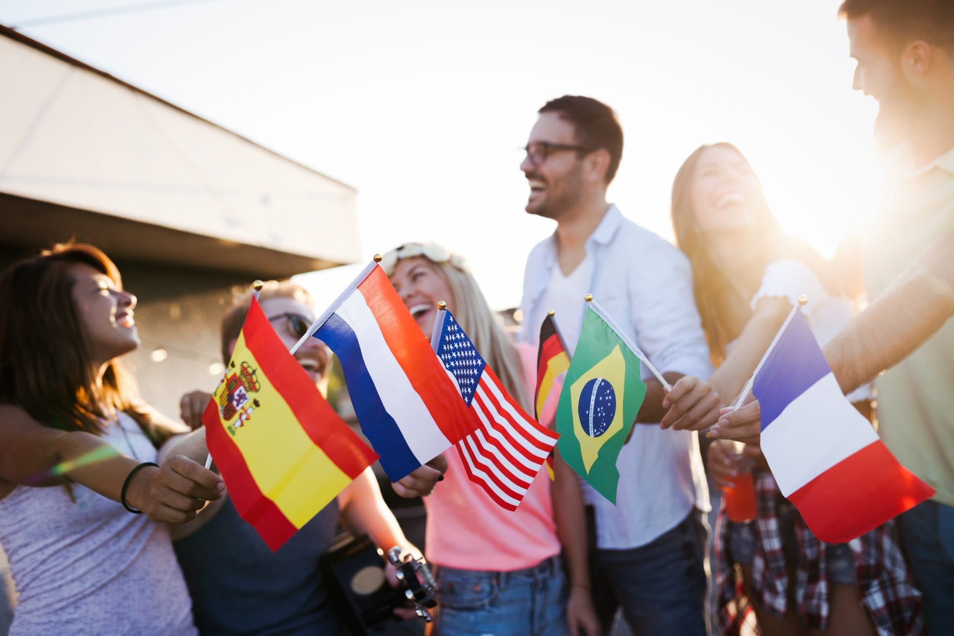 Diverse group of people holding flags, representing global collaboration.