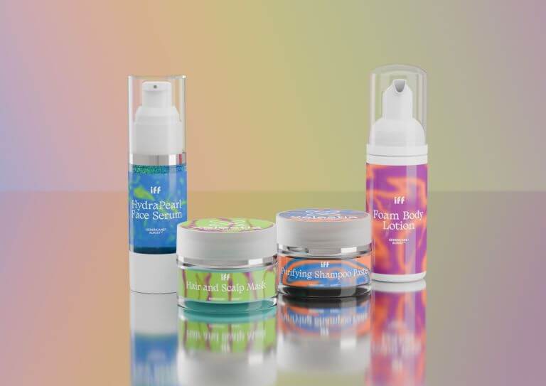 A set of four skincare and haircare products from IFF's Xelestia cosmetic formulation displayed on a reflective surface with a gradient background. The products include HydraPearl Face Serum, Hair and Scalp Mask, Purifying Shampoo Paste, and Foam Body Lotion.