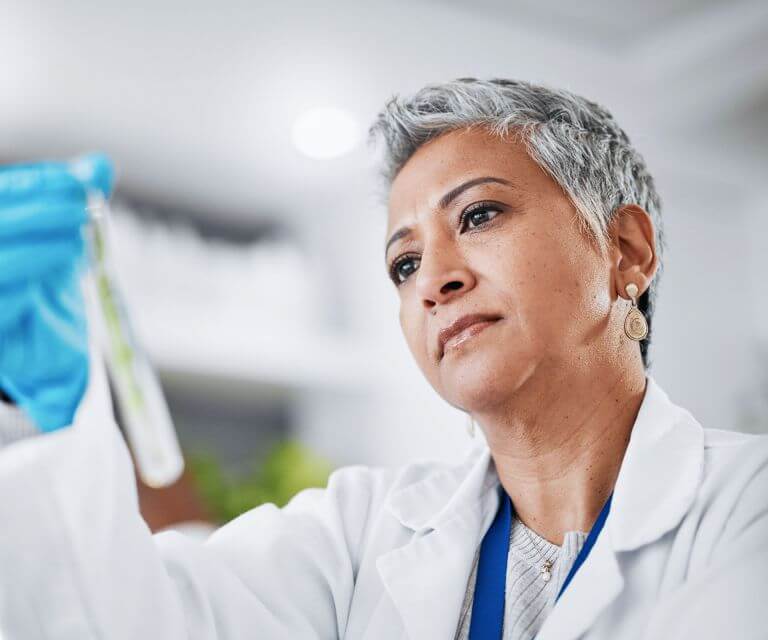 Image of a middle-aged southeast Asian scientist holding a test tube in the lab