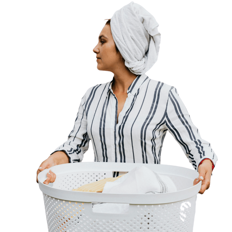 A person with a towel wrapped around their head, wearing a striped shirt, holding a white laundry basket filled with clothes.