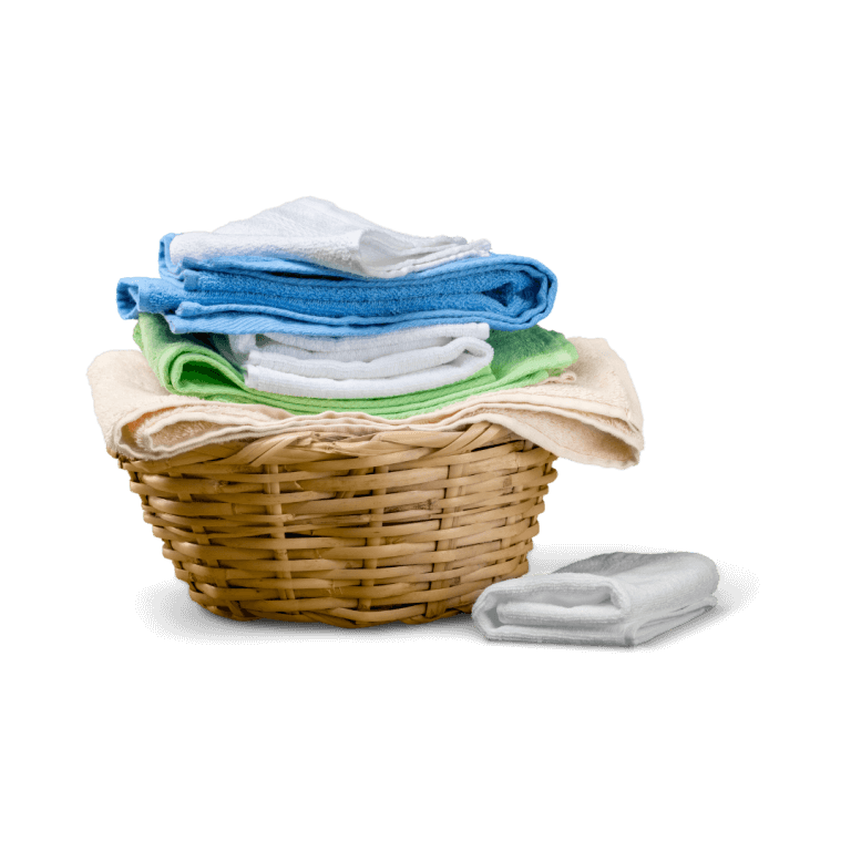 A wicker laundry basket filled with neatly folded towels in various colors, including blue, green, and beige. A single folded towel is placed next to the basket.