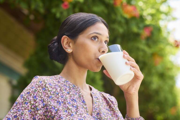 Person holding a glass full of drinkable yogurt