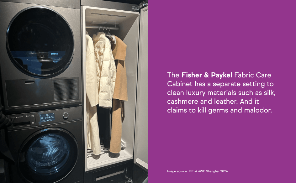 An open Fisher & Paykel Fabric Care Cabinet with coats hanging inside, next to a stacked washer and dryer unit.