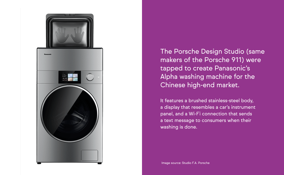 A high-end Panasonic Alpha washing machine designed by Porsche Design Studio, featuring a brushed stainless-steel body and a car-inspired display.