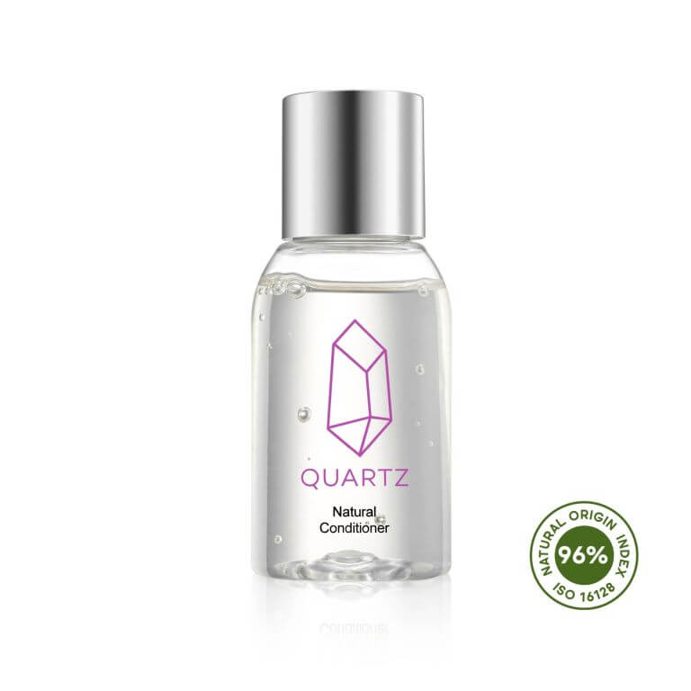 A clear bottle of Quartz Natural Conditioner with a silver cap and a purple geometric crystal design on the label. The bottle is marked with 