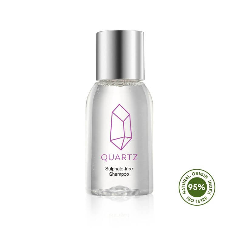 A clear plastic bottle with a silver cap containing Quartz Sulphate-free Shampoo. The bottle has a purple geometric crystal logo and the word 