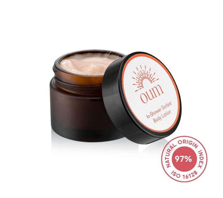 A brown jar of body lotion with a black lid partially open, revealing a creamy substance inside. The label on the lid reads 