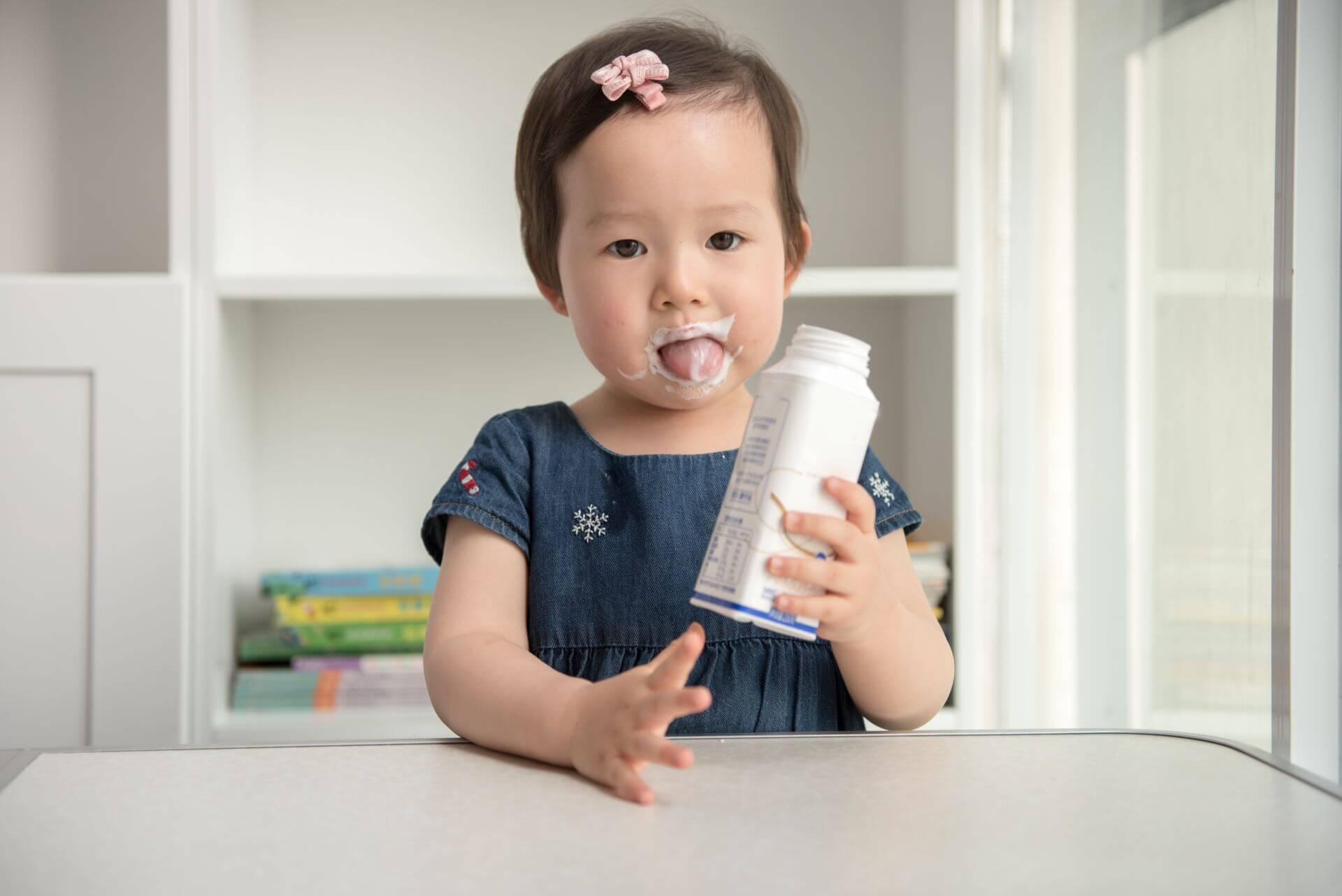 Child holding a bottle of drinking yogurt