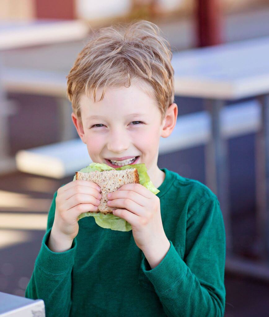 Kid eating a sandwich made with fresh bread