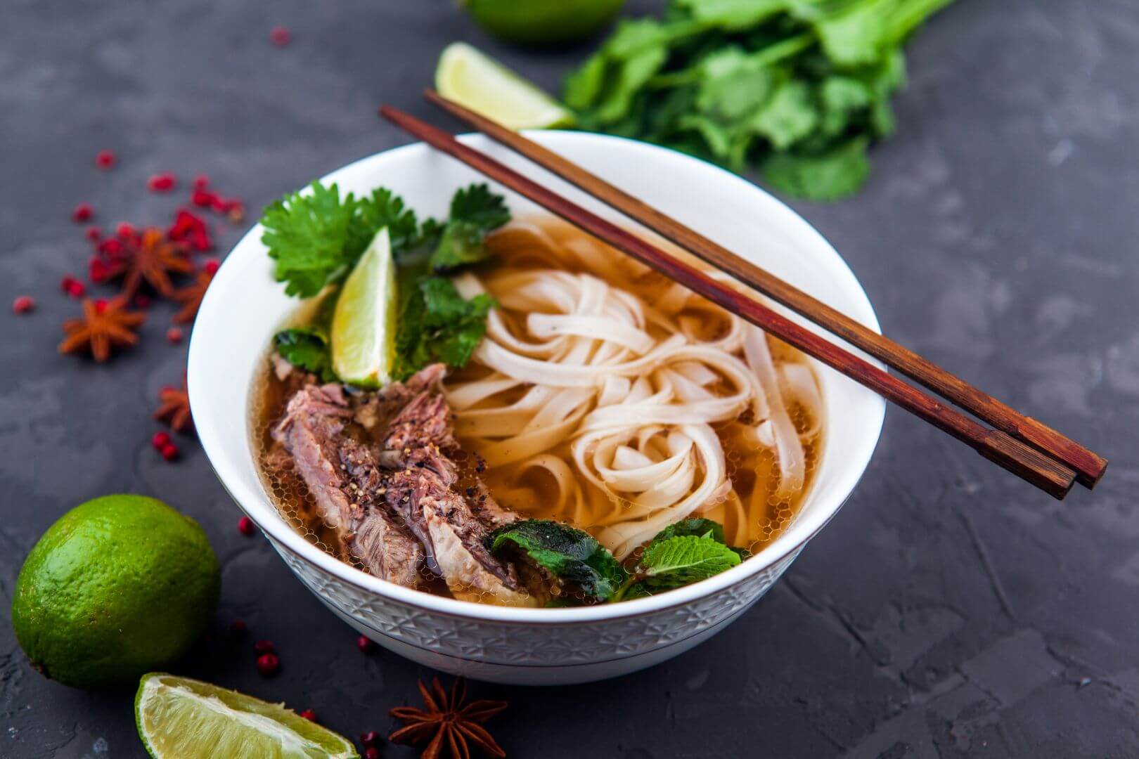 bowl of noodles with mushrooms, spices, flavors, vegetables in a white bowl with chopsticks on the side
