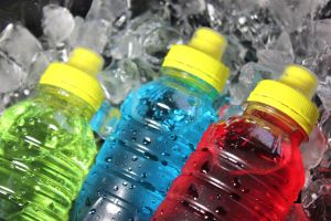 Bottles of brightly colored sports drinks, sitting on top of ice 