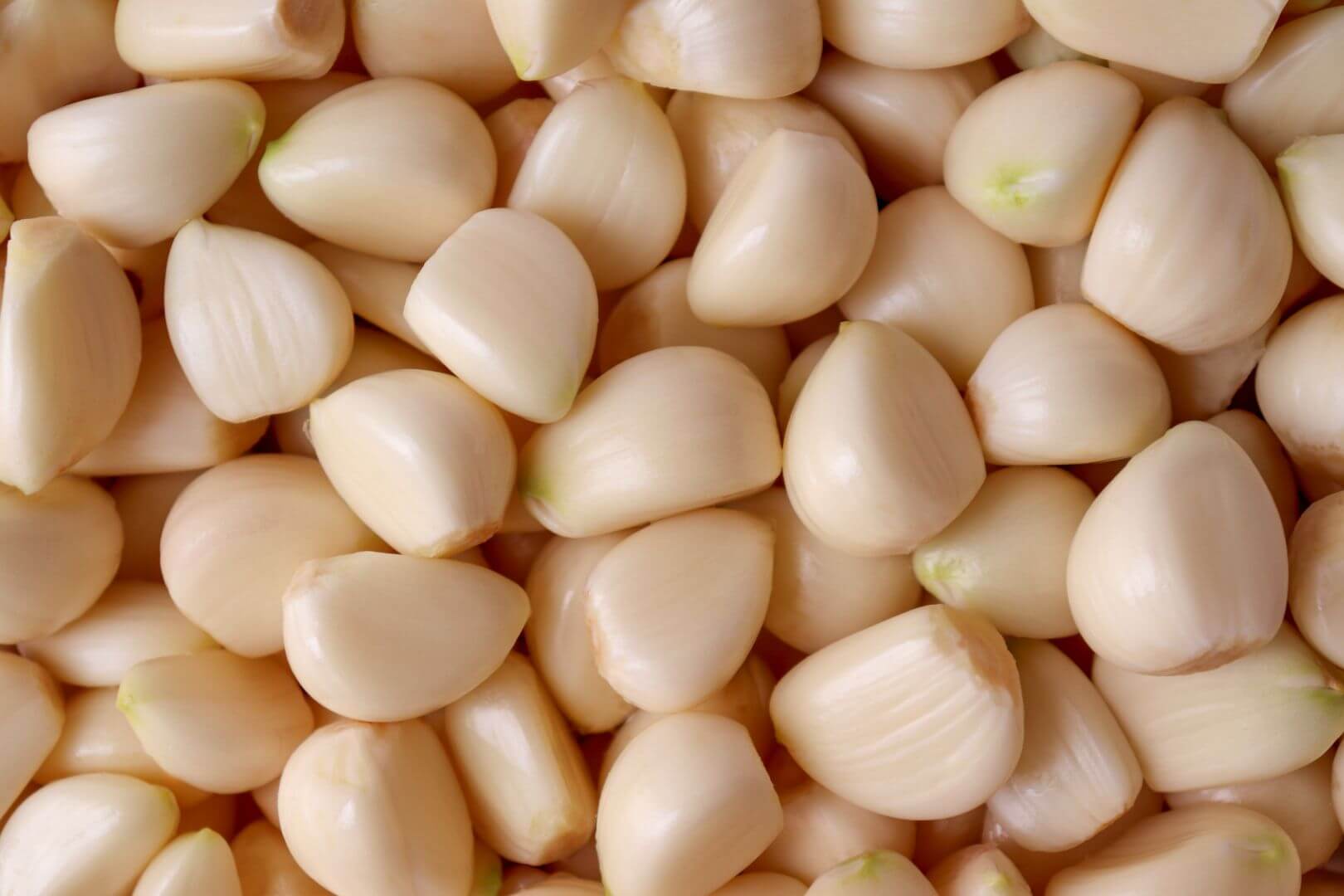 Macro shot of numerous garlic cloves taking up the entire image