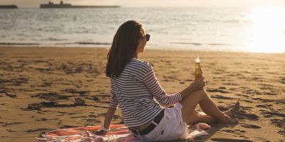 girl drinking beer in a beach